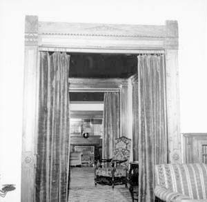 Looking north past chair in entry hall to fireplace in living room